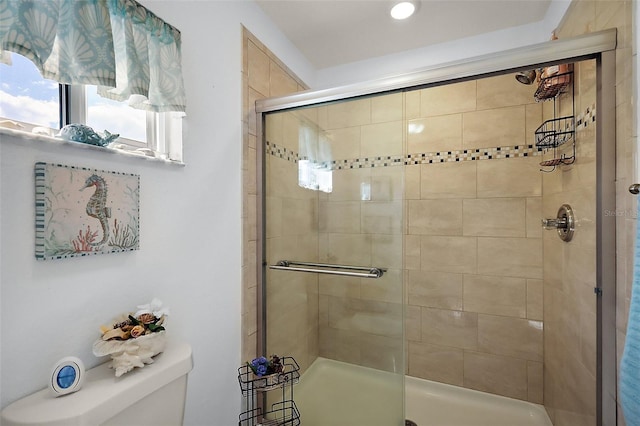 bathroom with a shower stall and toilet