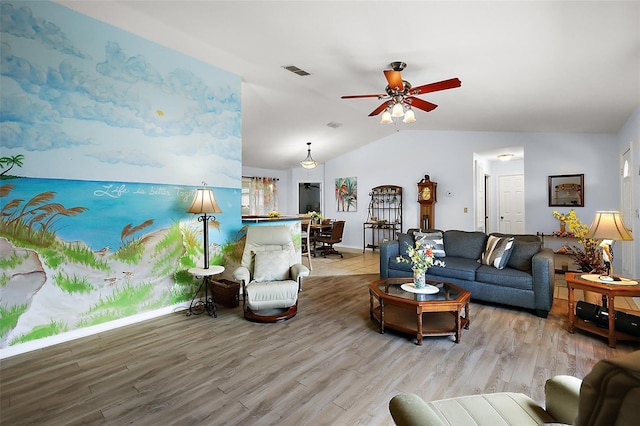 living area with a ceiling fan, lofted ceiling, visible vents, and wood finished floors