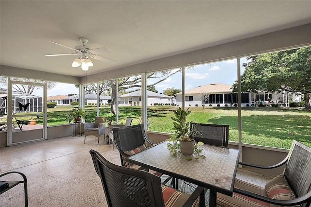 sunroom featuring a ceiling fan and a residential view