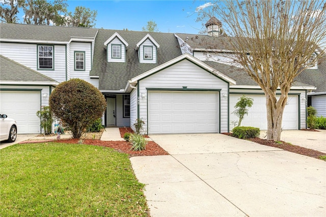 townhome / multi-family property featuring a shingled roof, an attached garage, driveway, and a front lawn