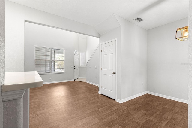 spare room with baseboards, visible vents, and wood finished floors