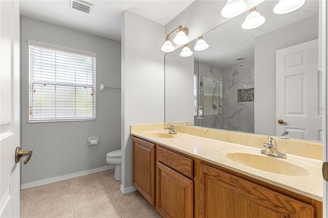 full bathroom featuring toilet, visible vents, a walk in shower, and a sink