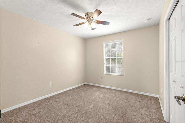 empty room with baseboards, a ceiling fan, a textured wall, a textured ceiling, and carpet flooring