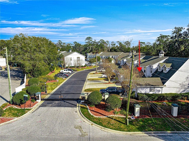 view of street featuring curbs, a gate, a gated entry, and a residential view