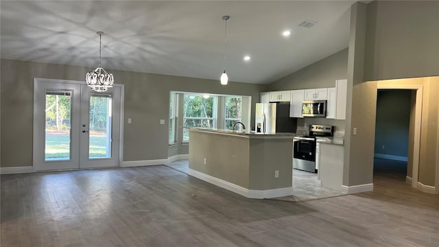 kitchen with visible vents, light wood-style floors, white cabinets, appliances with stainless steel finishes, and a center island with sink