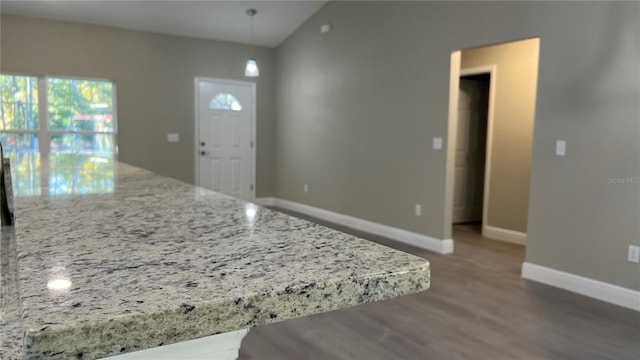 kitchen with light stone counters, pendant lighting, baseboards, and wood finished floors