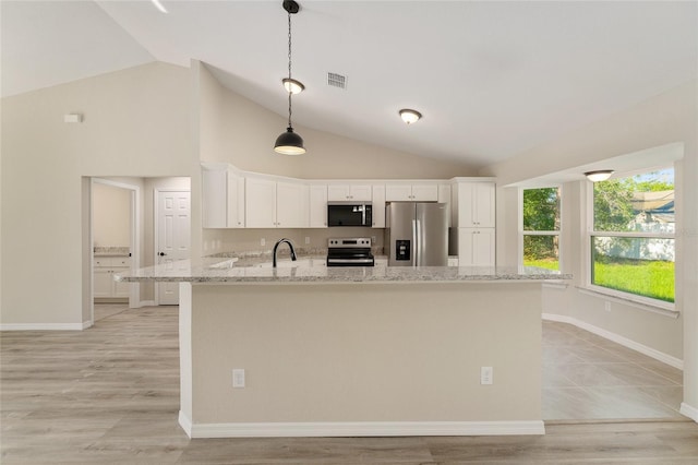 114 Bay Dr, Ocklawaha, FL 32179 - kitchen featuring stainless steel appliances, vaulted ceiling, a sink, white cabinets, and light stone countertops