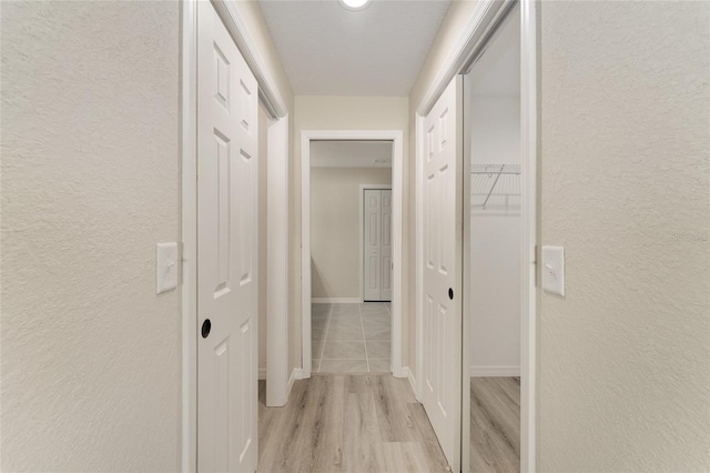 114 Bay Dr, Ocklawaha, FL 32179 - corridor featuring light wood-type flooring, a textured wall, and baseboards