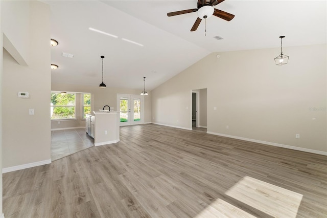 114 Bay Dr, Ocklawaha, FL 32179 - unfurnished living room featuring french doors, vaulted ceiling, ceiling fan, baseboards, and light wood finished floors