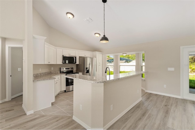 114 Bay Dr, Ocklawaha, FL 32179 - kitchen with appliances with stainless steel finishes, a center island with sink, plenty of natural light, light wood finished floors, and lofted ceiling