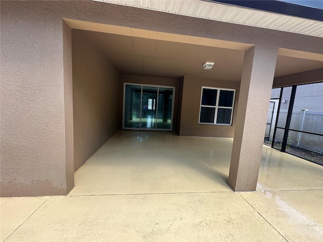 entrance to property featuring a patio and stucco siding