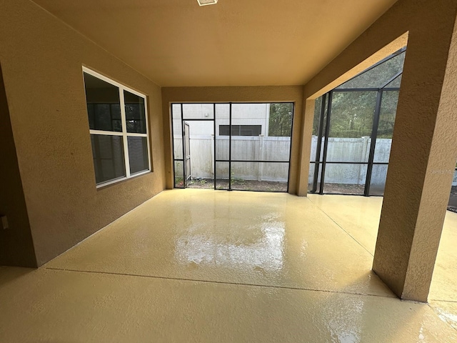 view of patio with fence and a lanai