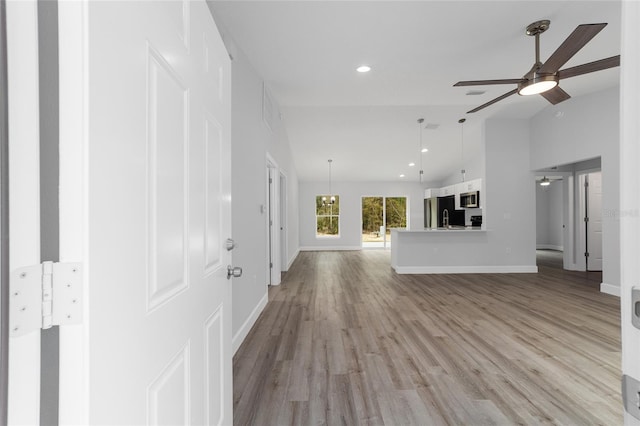 interior space with ceiling fan, high vaulted ceiling, recessed lighting, baseboards, and light wood-style floors