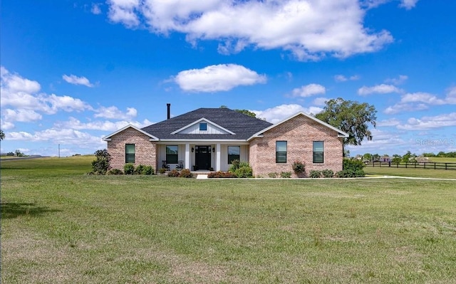 craftsman-style house featuring brick siding, fence, and a front yard