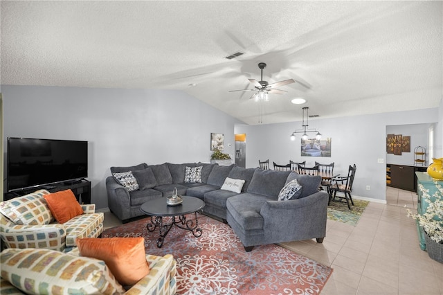 living area with baseboards, visible vents, lofted ceiling, a textured ceiling, and light tile patterned flooring