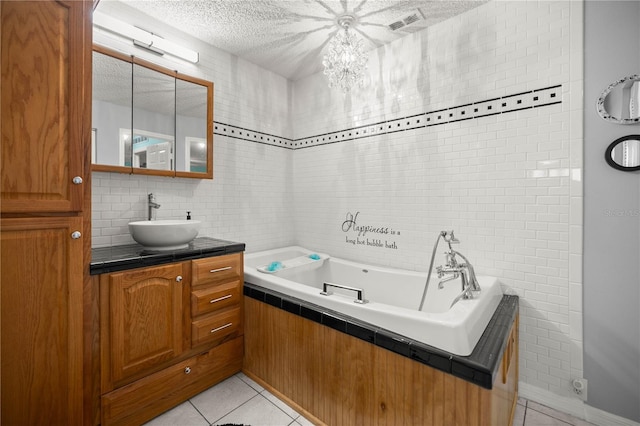 bathroom featuring a textured ceiling, a garden tub, tile patterned flooring, vanity, and tile walls