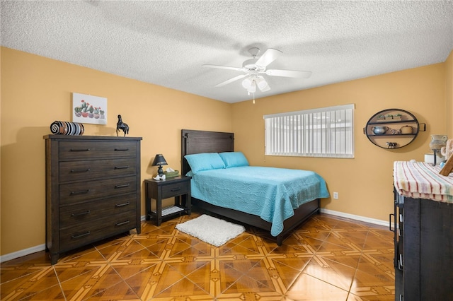 bedroom with ceiling fan, a textured ceiling, and baseboards