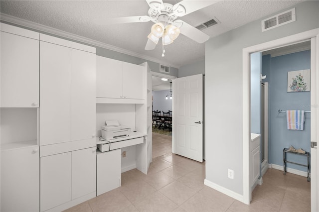 interior space with visible vents, a textured ceiling, and white cabinetry