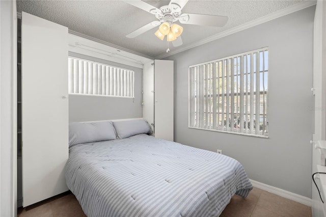 bedroom with crown molding, a ceiling fan, a textured ceiling, tile patterned flooring, and baseboards