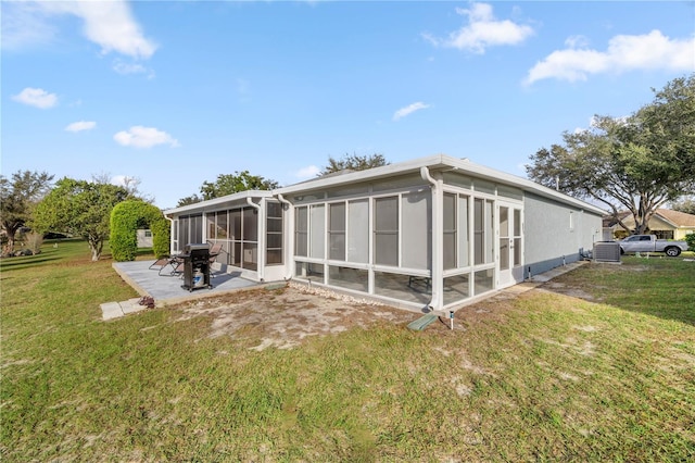 back of house with a lawn, a patio area, cooling unit, and a sunroom