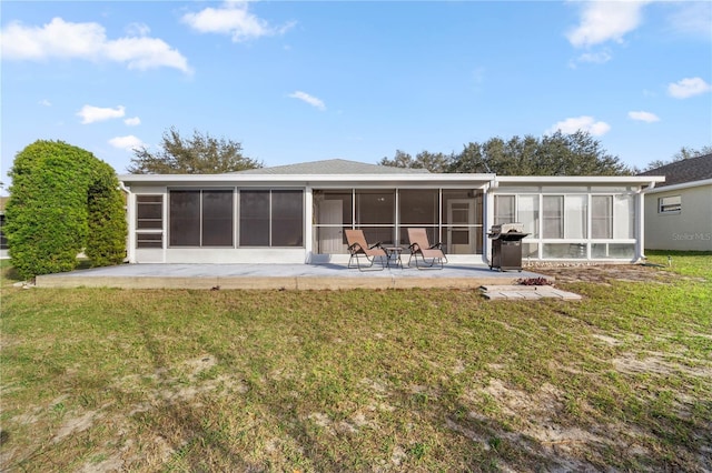 rear view of property with a patio area, a sunroom, and a lawn