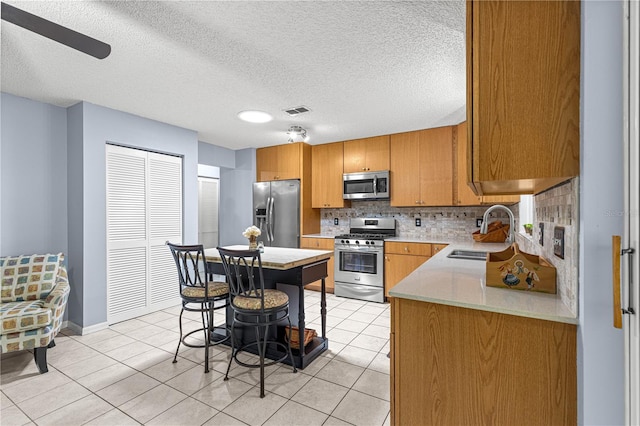 9770 SW 97th Pl, Ocala, FL 34481 - kitchen featuring appliances with stainless steel finishes, a sink, light countertops, decorative backsplash, and light tile patterned flooring
