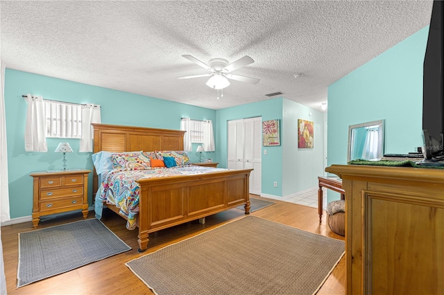 9770 SW 97th Pl, Ocala, FL 34481 - bedroom featuring light wood-style flooring, ceiling fan, a closet, baseboards, and a textured ceiling
