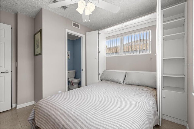 9770 SW 97th Pl, Ocala, FL 34481 - tiled bedroom with a textured ceiling, ensuite bathroom, a ceiling fan, and baseboards