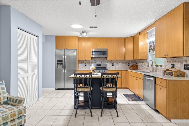 9770 SW 97th Pl, Ocala, FL 34481 - kitchen with stainless steel appliances, backsplash, a sink, light countertops, and light tile patterned floors