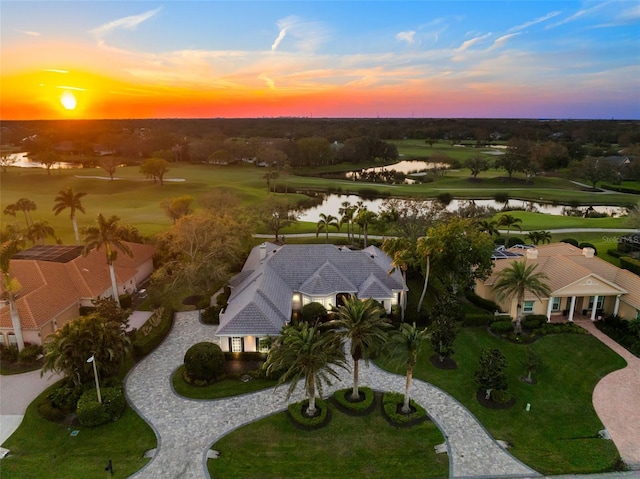 aerial view at dusk featuring a water view