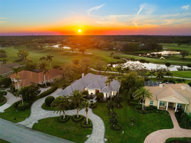 aerial view at dusk featuring a water view