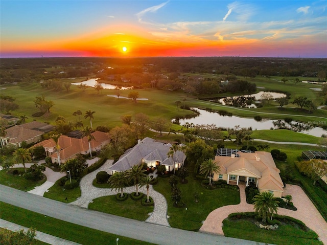 aerial view at dusk featuring a water view