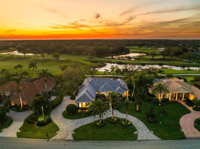 aerial view at dusk featuring a water view