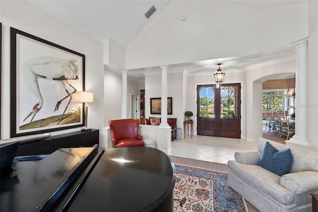 tiled living area with crown molding, a notable chandelier, decorative columns, and high vaulted ceiling