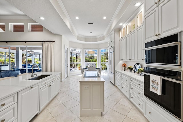 kitchen featuring ornamental molding, a center island, a sink, and paneled built in fridge