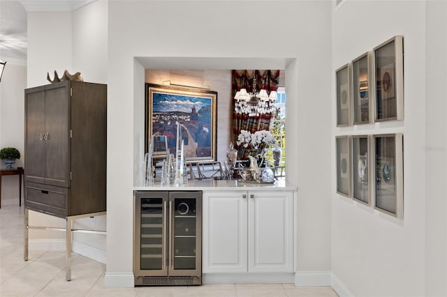 bar with beverage cooler, baseboards, ornamental molding, and light tile patterned flooring