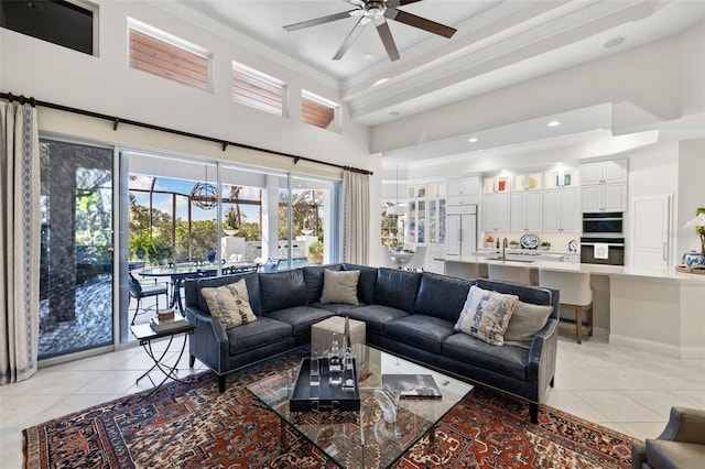 living area with light tile patterned floors, ceiling fan, recessed lighting, a towering ceiling, and crown molding