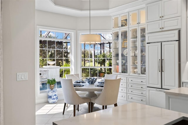 tiled dining area with a raised ceiling