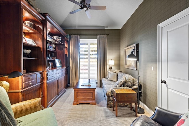 living area featuring light carpet, baseboards, vaulted ceiling, and a ceiling fan