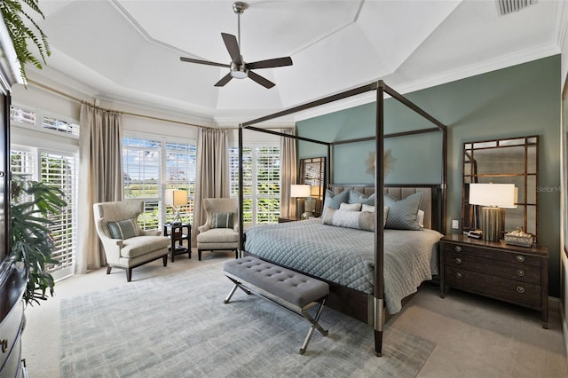 carpeted bedroom featuring a ceiling fan, visible vents, a raised ceiling, and crown molding