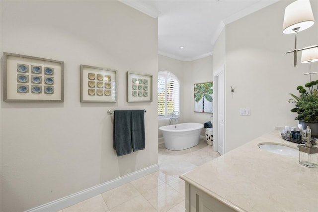 bathroom with vanity, baseboards, a freestanding bath, ornamental molding, and tile patterned floors