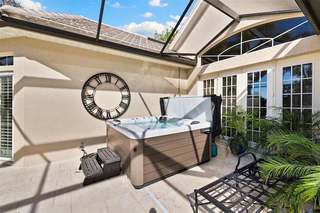 view of patio / terrace with french doors, a hot tub, and a lanai