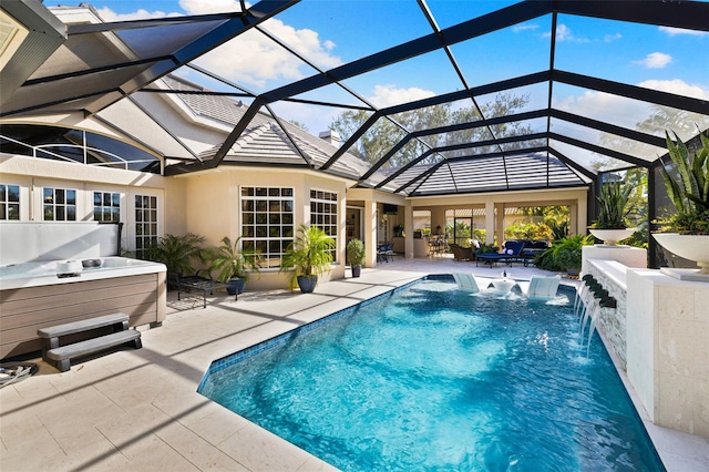 pool featuring glass enclosure, a patio area, and a hot tub