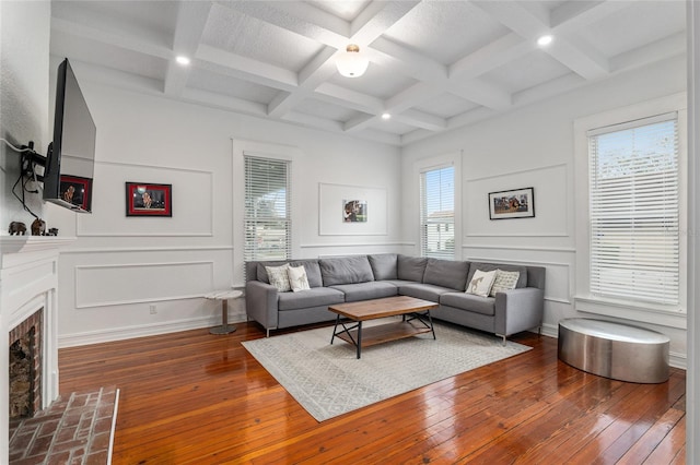 living area featuring a healthy amount of sunlight, hardwood / wood-style flooring, a fireplace, and a decorative wall