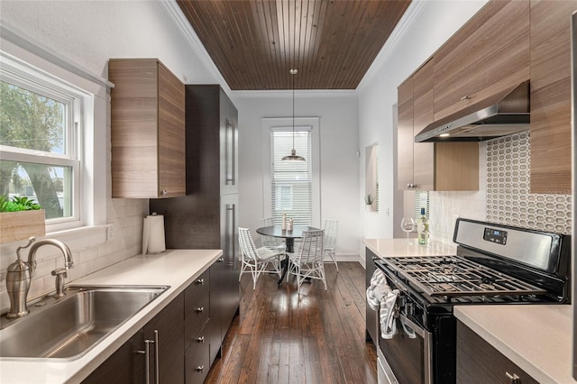 kitchen featuring gas stove, light countertops, a sink, and range hood