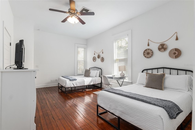 bedroom featuring ceiling fan, hardwood / wood-style floors, visible vents, and baseboards