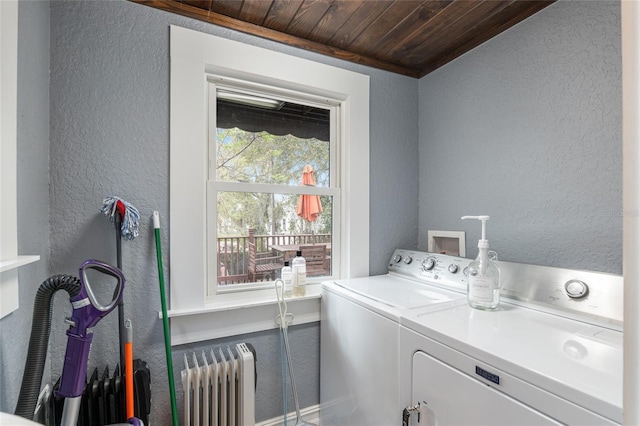 clothes washing area with a textured wall, wooden ceiling, laundry area, washer and dryer, and radiator heating unit