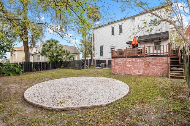 back of house featuring a fenced backyard, a yard, a deck, and stairs