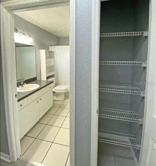 bathroom with tile patterned floors, toilet, and vanity