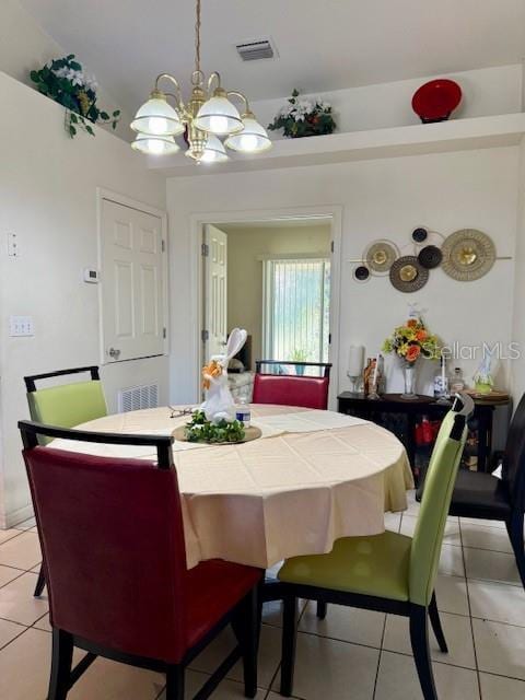 dining room with a notable chandelier, light tile patterned flooring, and visible vents